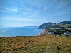 A grassy clifftop overlooking a blue sea and sky view.